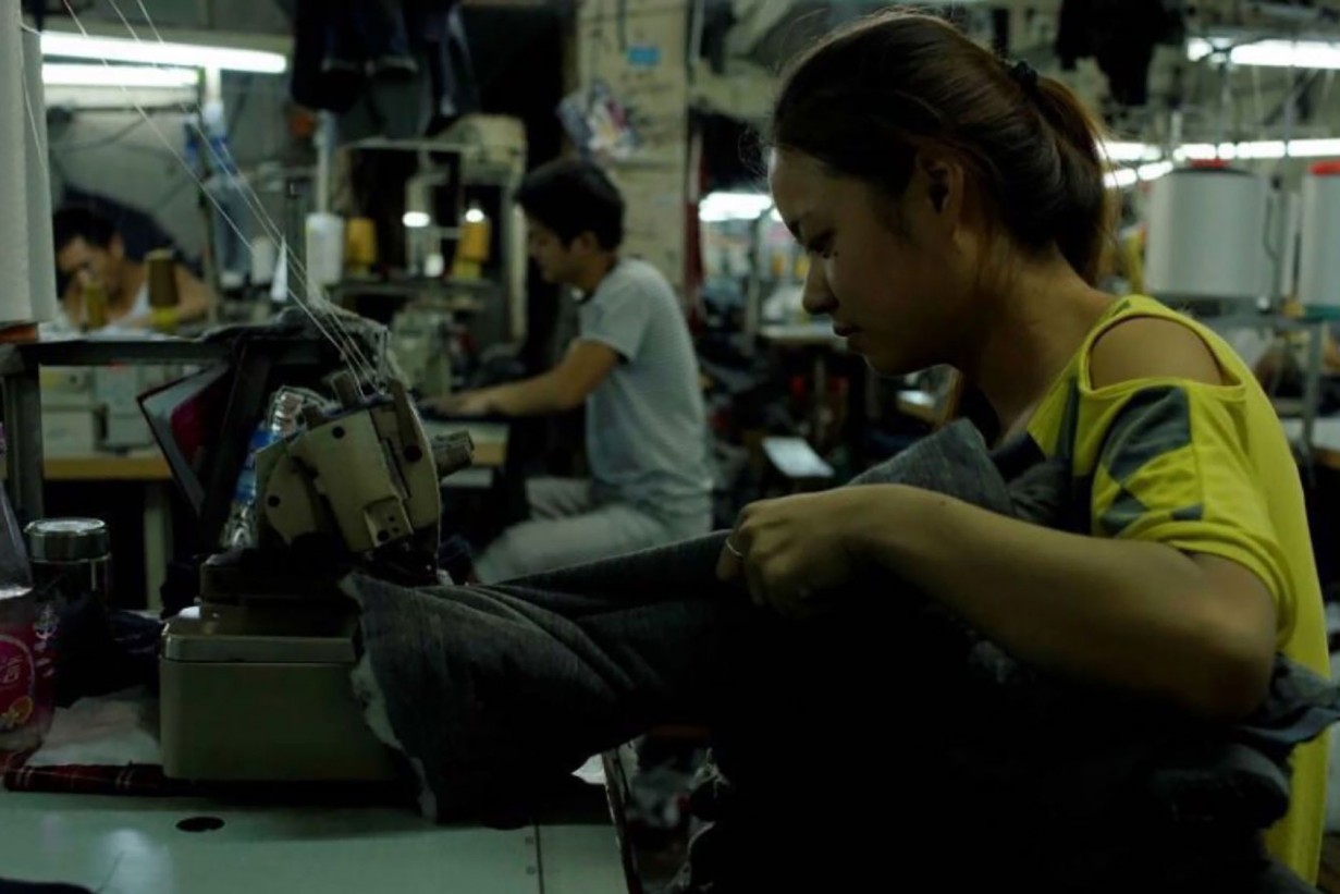 Person sitzt an einer Nähmaschine