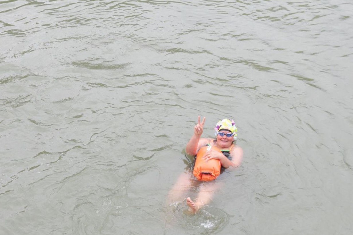 Person mit Badehaube schwimmt im Donaukanal
