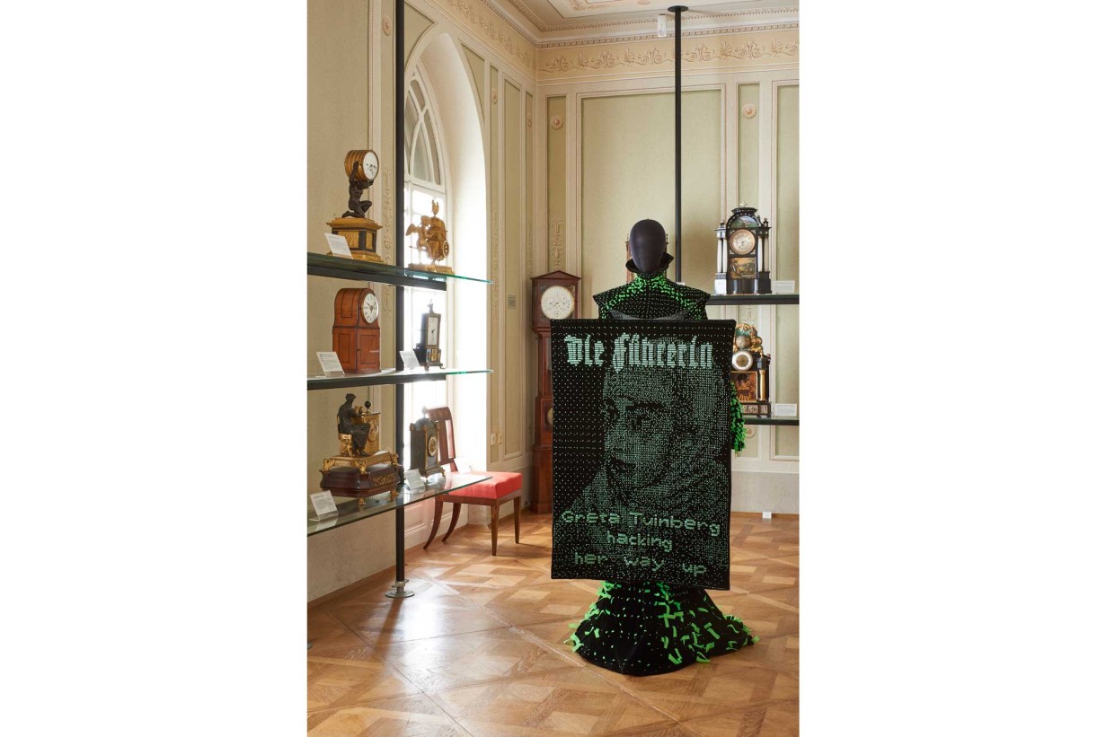 A Biedermeier-style room with a mannequin wearing a futuristic fashion design. 