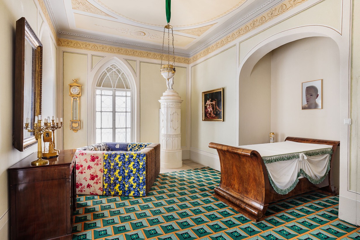 Frontal view of a room, a colorful carpet and pieces of furniture