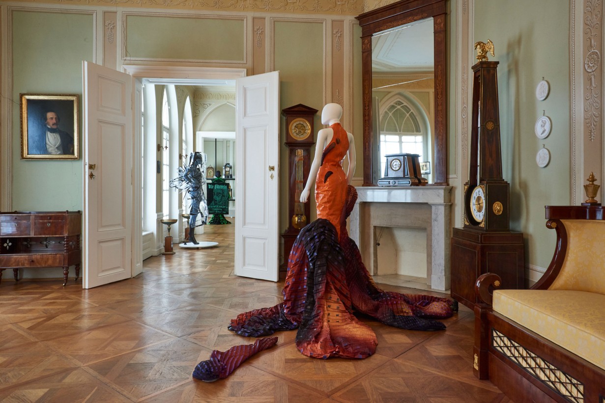 A Biedermeier-style room with a mannequin wearing a futuristic fashion design. 