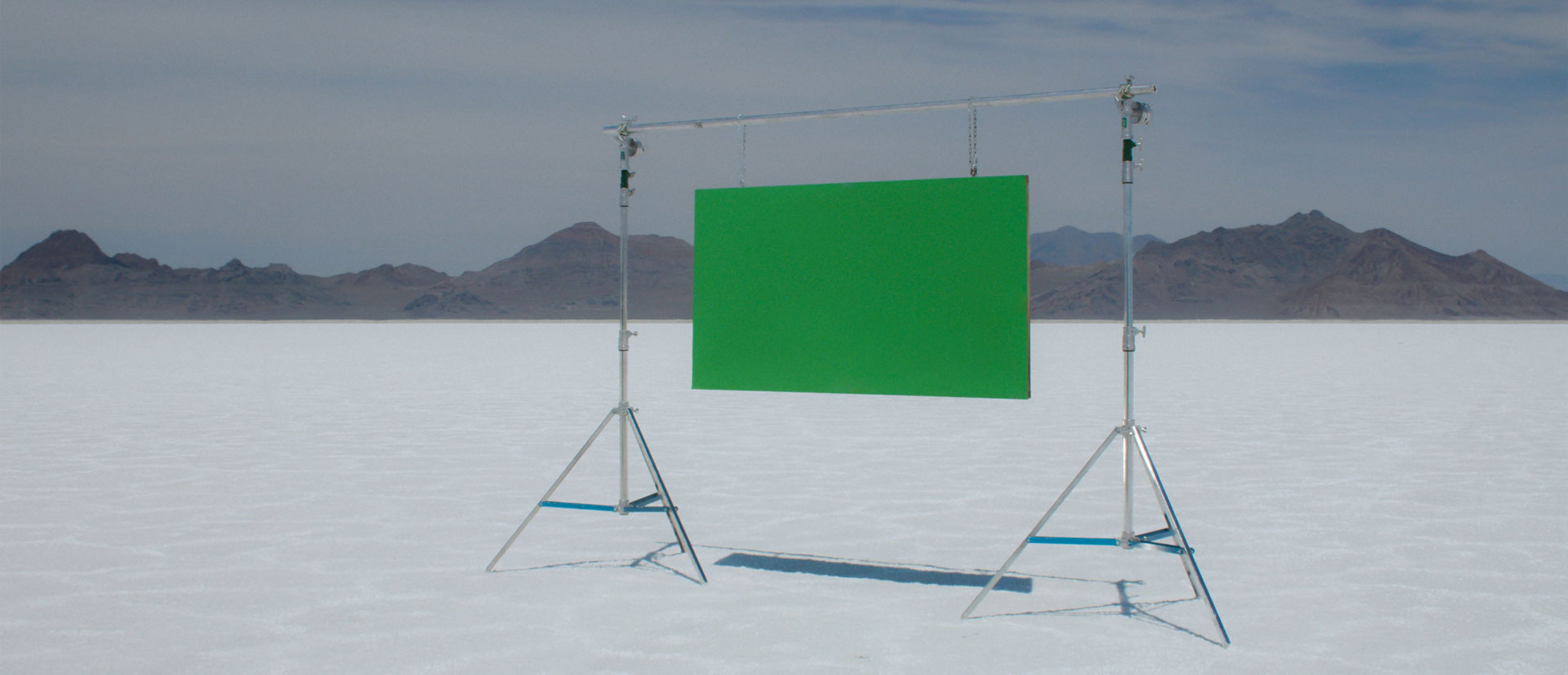 A green screen on a stand in the middle of a desert landscape.
