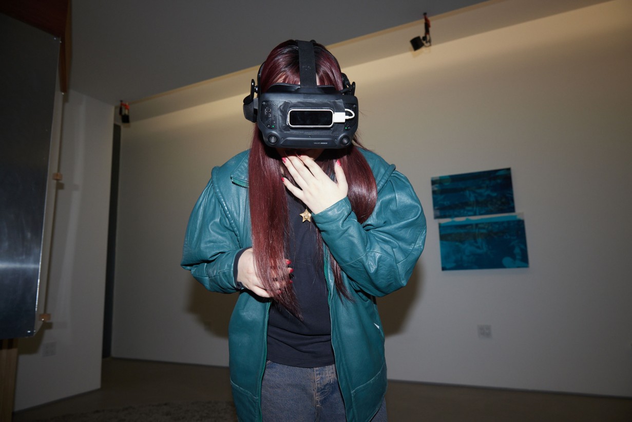 Eine Frau mit Collegejacke trägt eine VR Brille