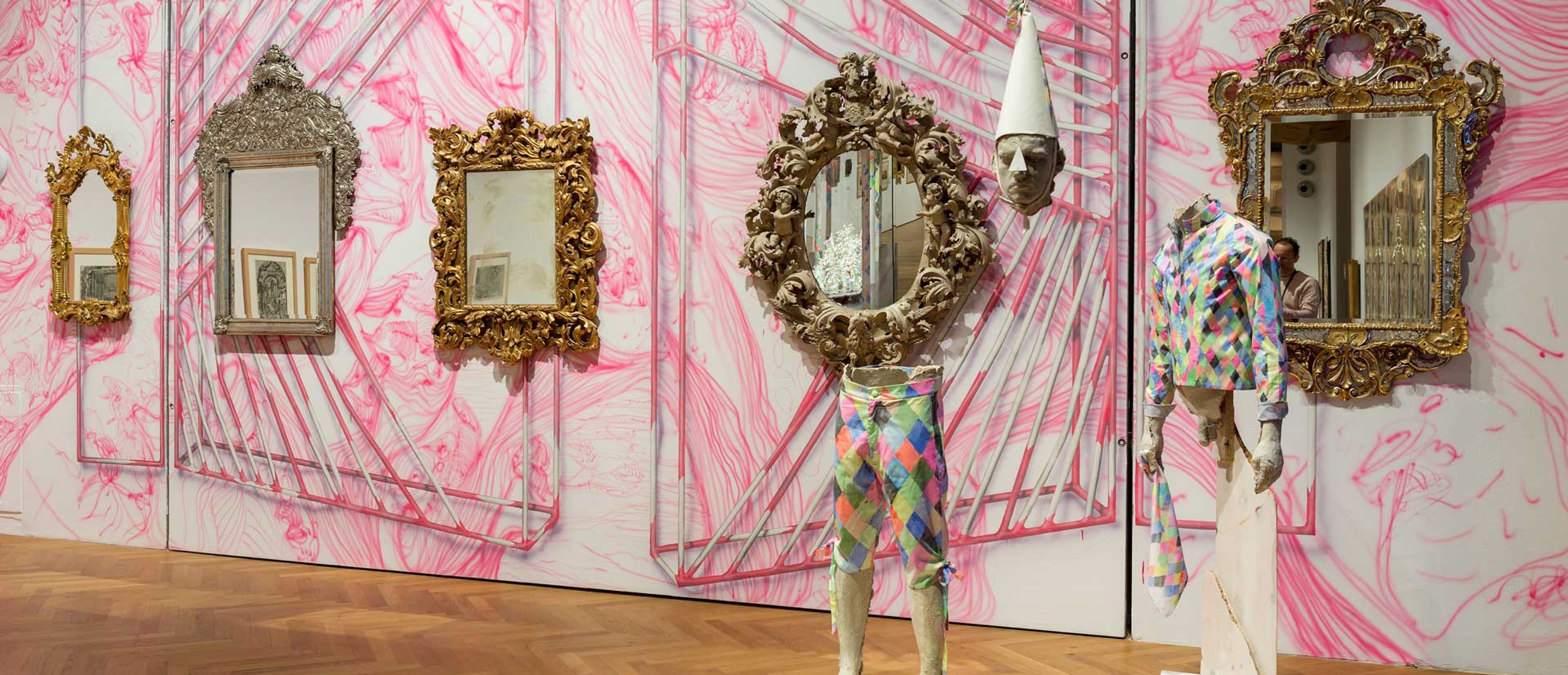 Ausstellungsraum mit Objekten, pinke Tapete mit Muster