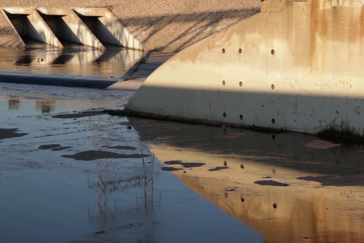 Ein betonierter Kanal in dem ein kleiner Fluss fließt