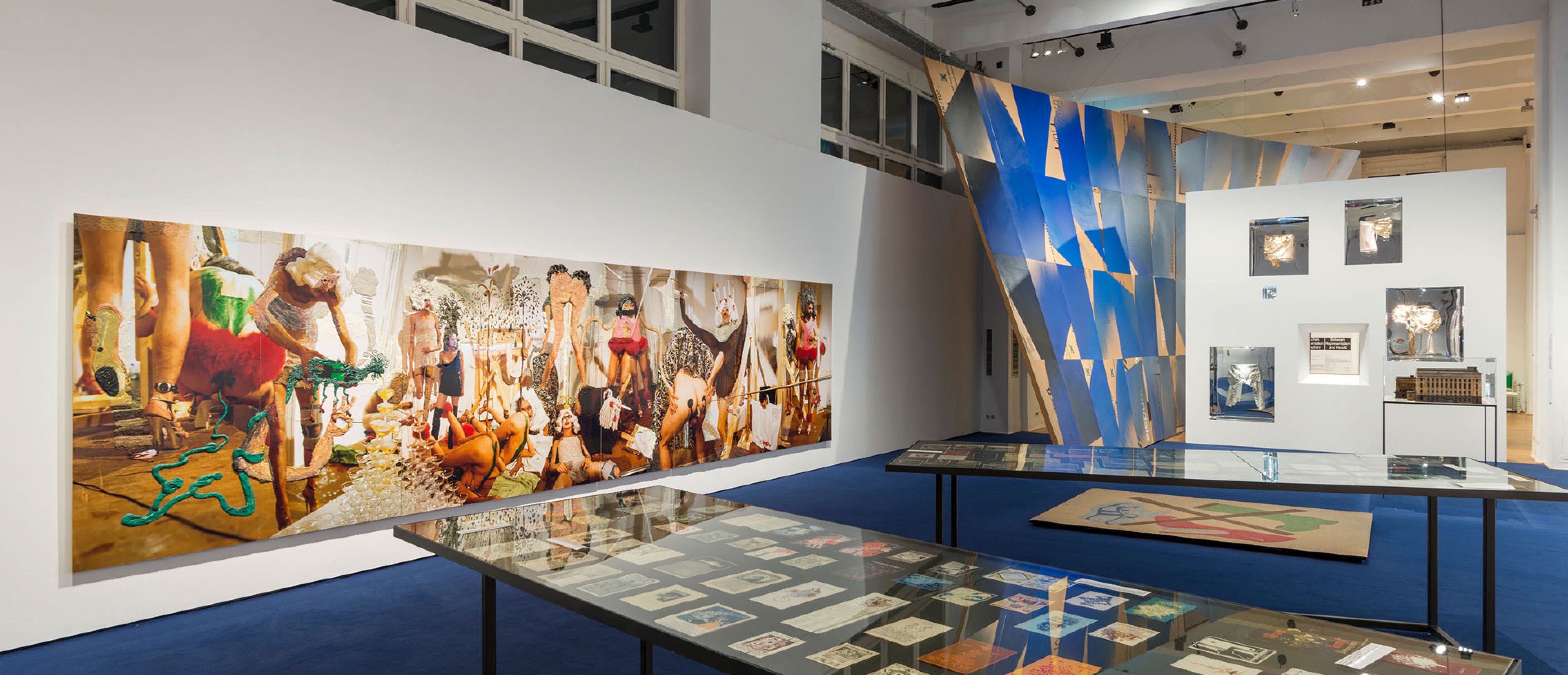 Ausstellungsraum mit Objekten, an einer Wand ist ein großes Gemälde zu sehen.